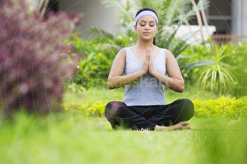 girl practicing yoga in park with eyes closed 