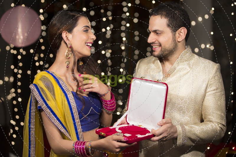 husband gifting wife a necklace 