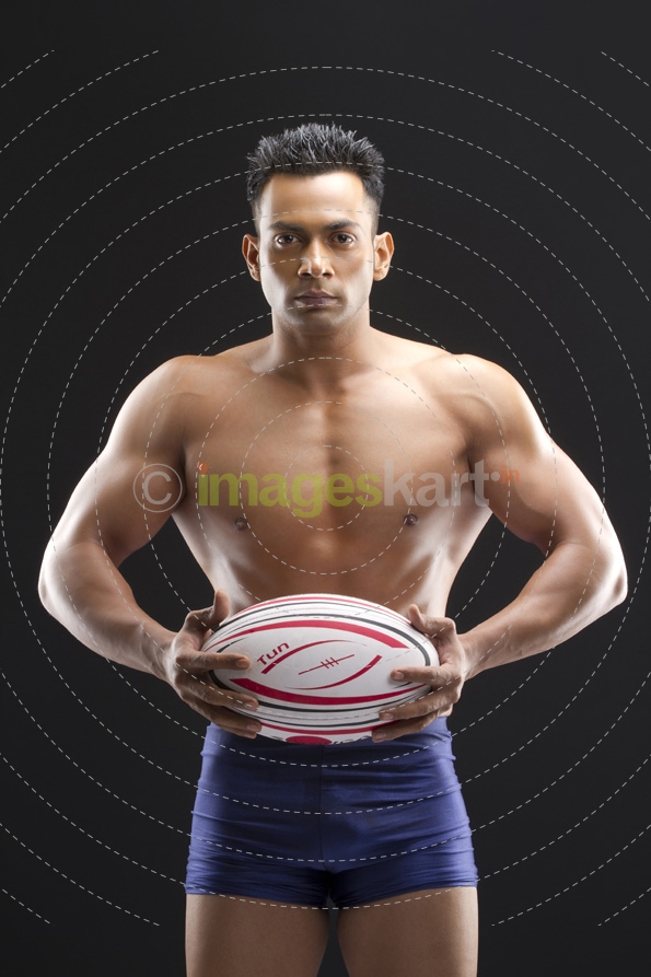 muscle man posing with a sports ball