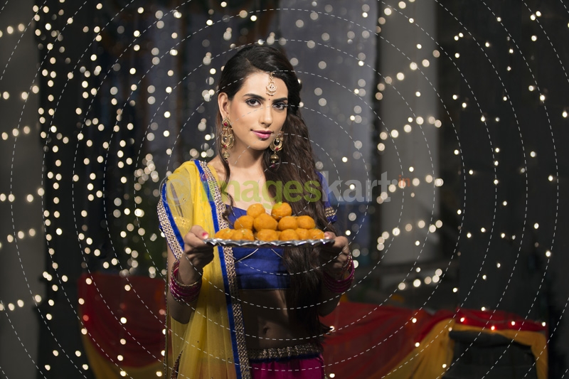 woman with a plate of ladoos