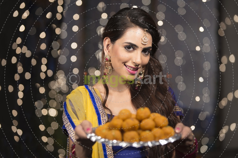 woman with a plate of ladoos