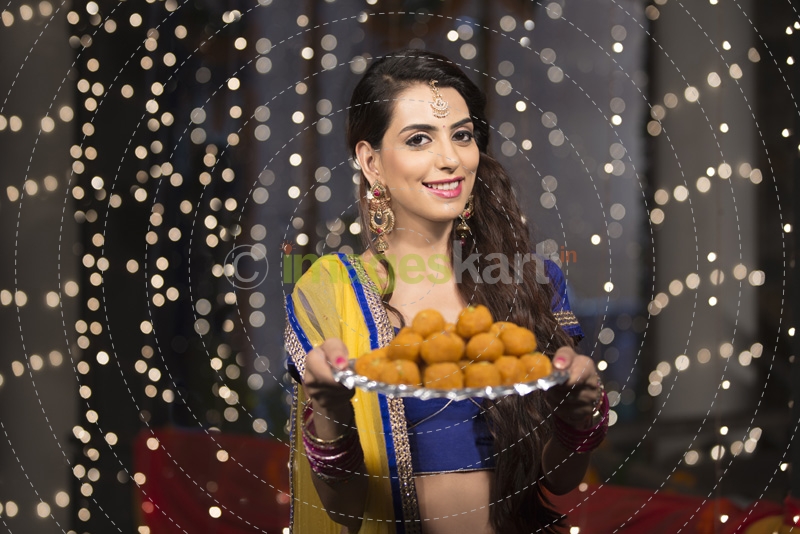 woman with a plate of ladoos 