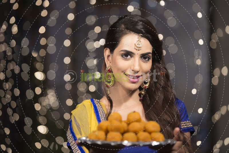 woman with a plate of ladoos