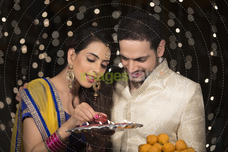 husband and wife with ladoo and thaali
