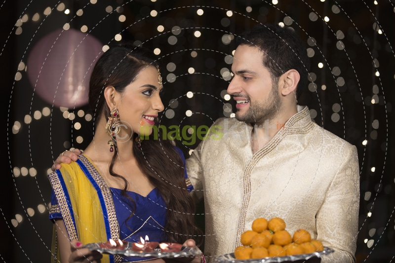 husband and wife with ladoo and thaali