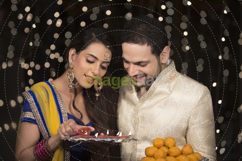 husband and wife with ladoo and thaali