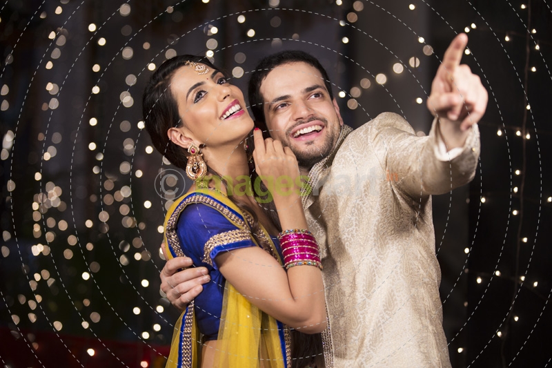 couple in traditional wear pointing towards something 