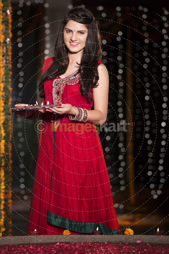 woman in traditional wear posing with pooja thali