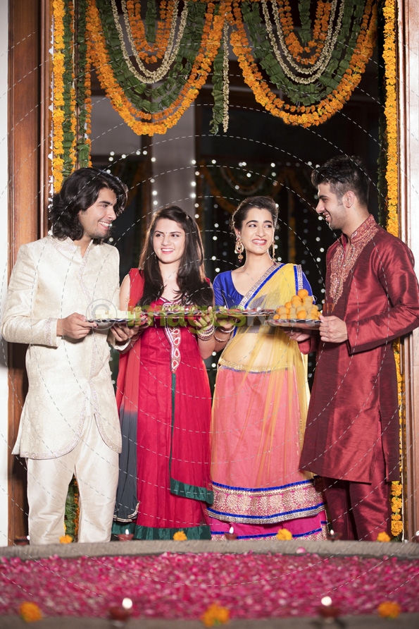 couples with sweets and thalis on diwali