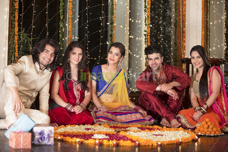 couple decorating home with flower rangoli