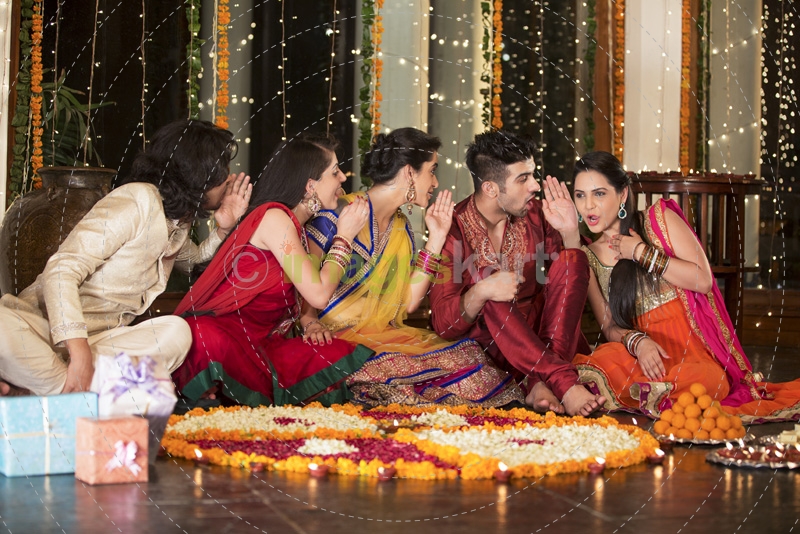 couple decorating home with flower rangoli and having fun 