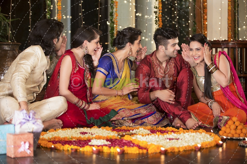couple decorating home with rangoli and having fun