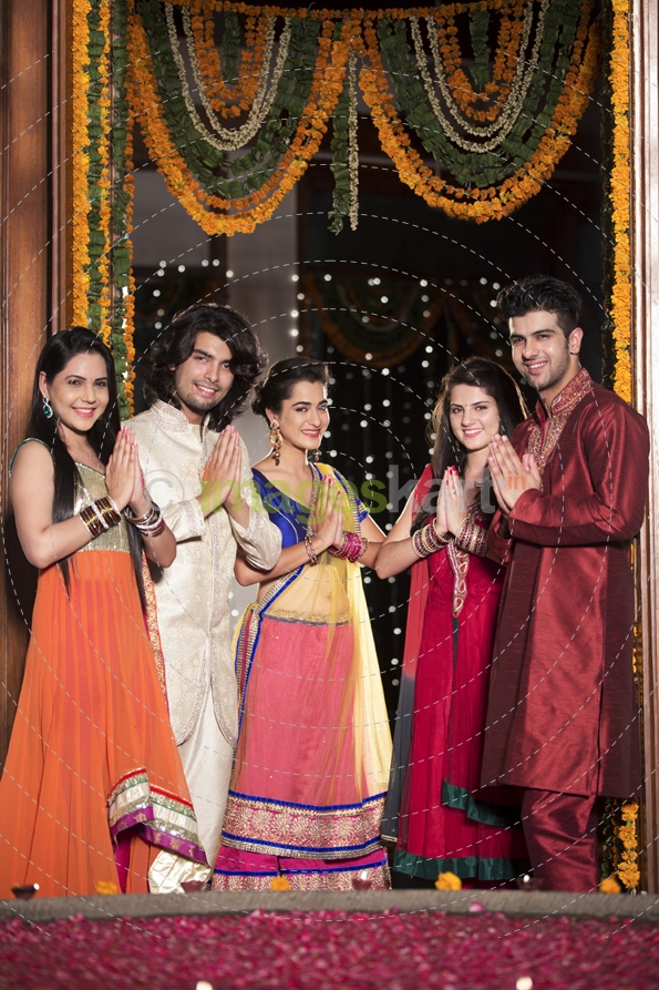 couples with folded hands standing at entrance gate on diwali
