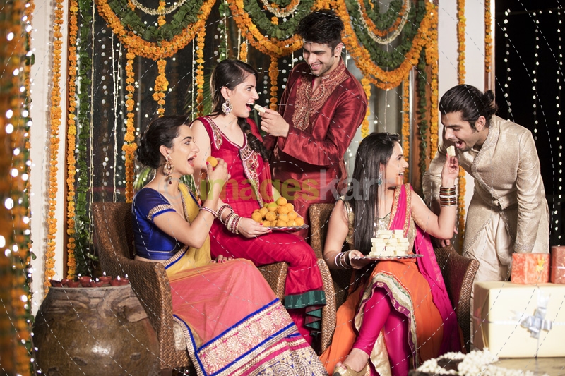 couples feeding sweets to each other on diwali  