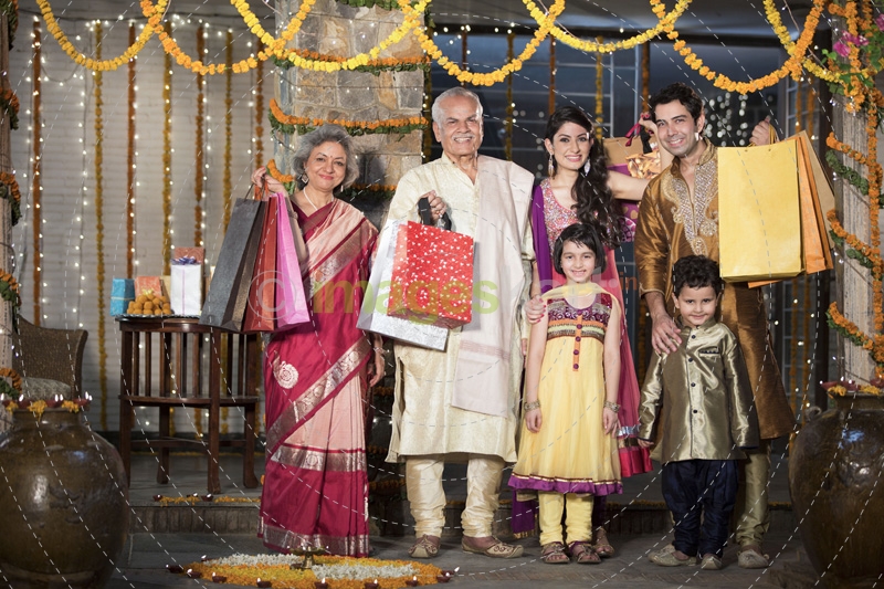 family with diwali gifts standing at entrance of house 