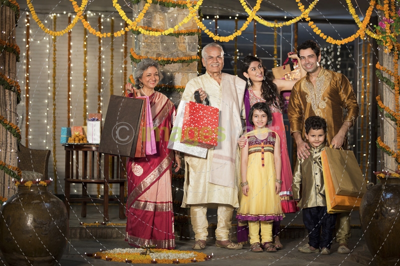 family with diwali gifts standing at entrance of house 