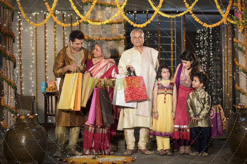 family with diwali gifts standing at entrance of house 