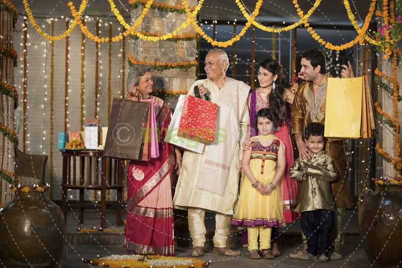 family with diwali gifts standing at entrance of house 