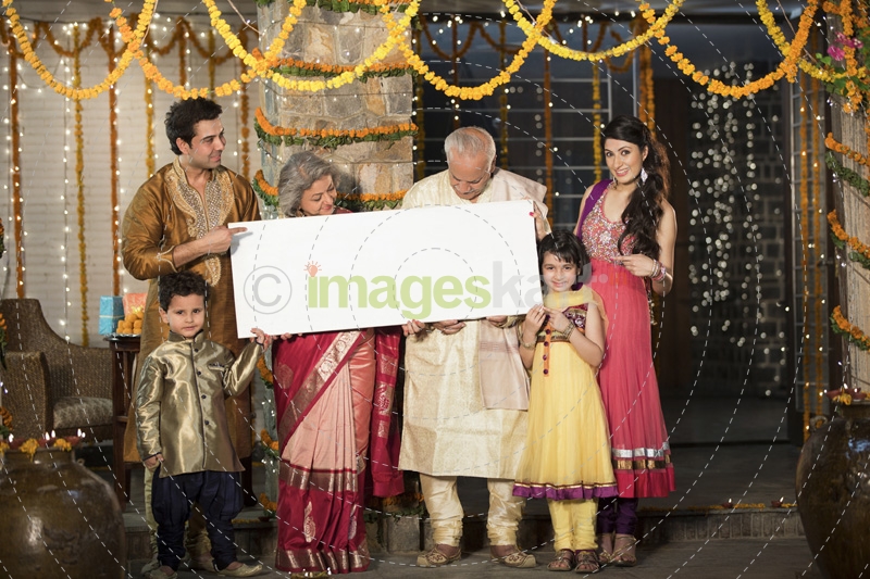 family standing at entrance with message board on diwali