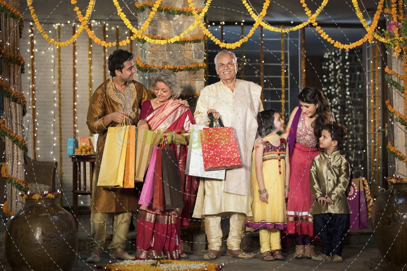 family with diwali gifts standing at entrance of house 