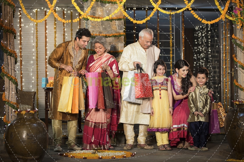 family with diwali gifts standing at entrance of house 