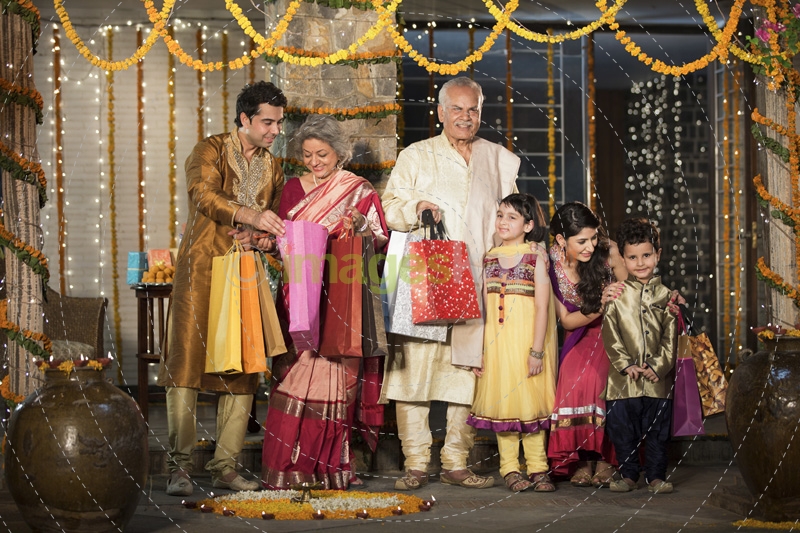 family with diwali gifts standing at entrance of house 