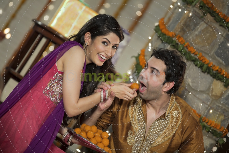 wife feeding ladoo to husband on diwali