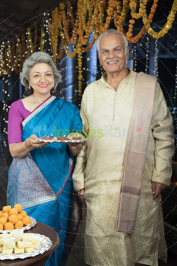 smiling old couple welcoming guests on diwali