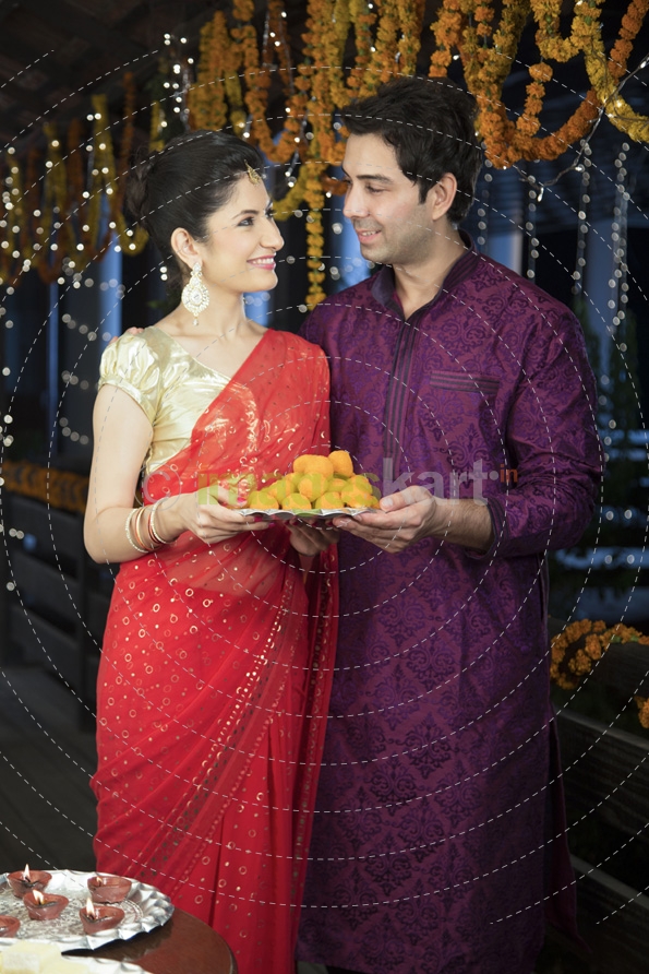 attractive young couple sharing diwali sweets