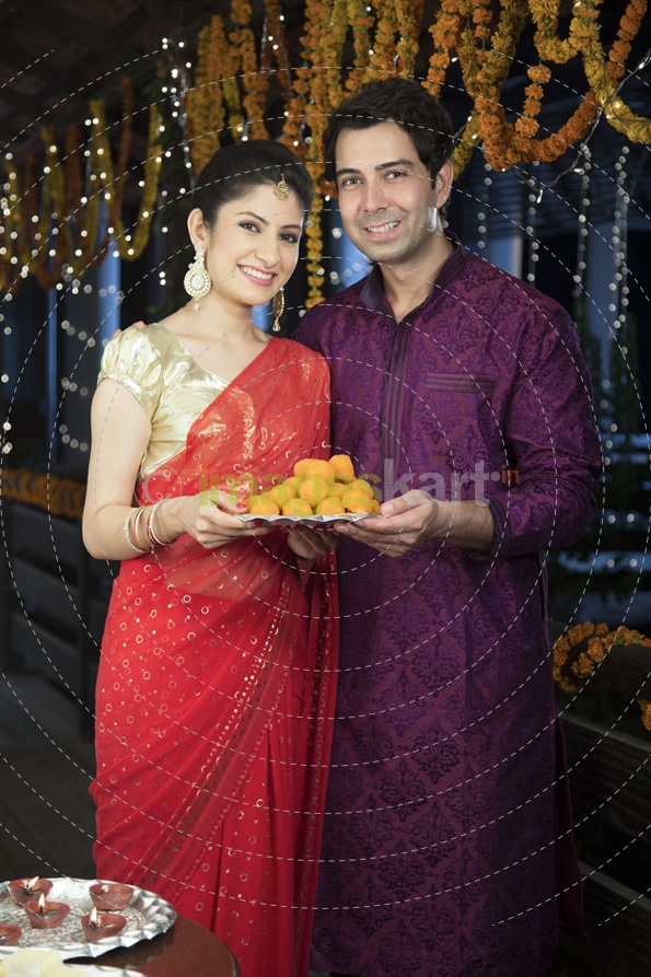 attractive young couple sharing diwali sweets
