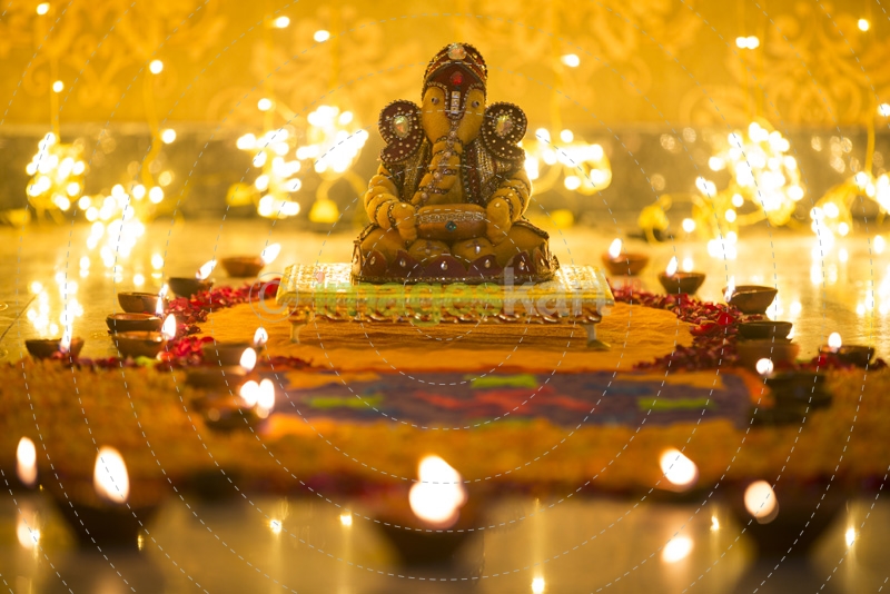 beautiful idol of ganesh placed against bright lights on diwali