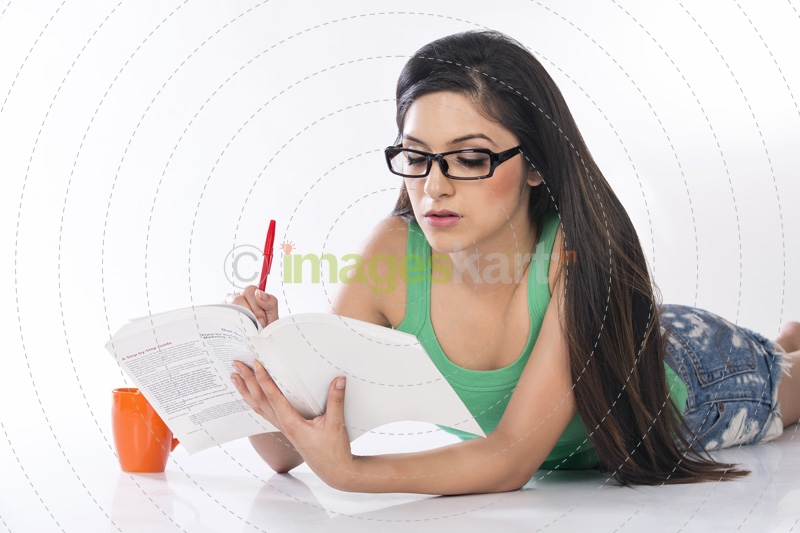 front view of a young teenage girl holding a pencil and a book