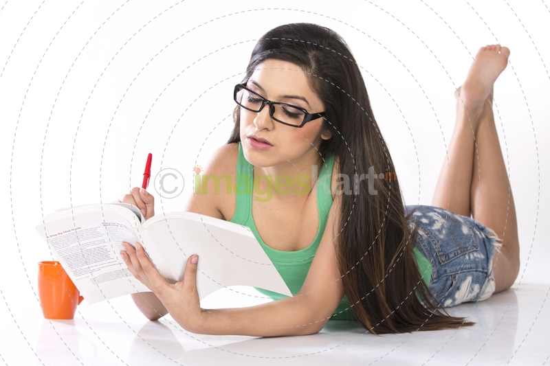 front view of a young teenage girl holding a pencil and a book