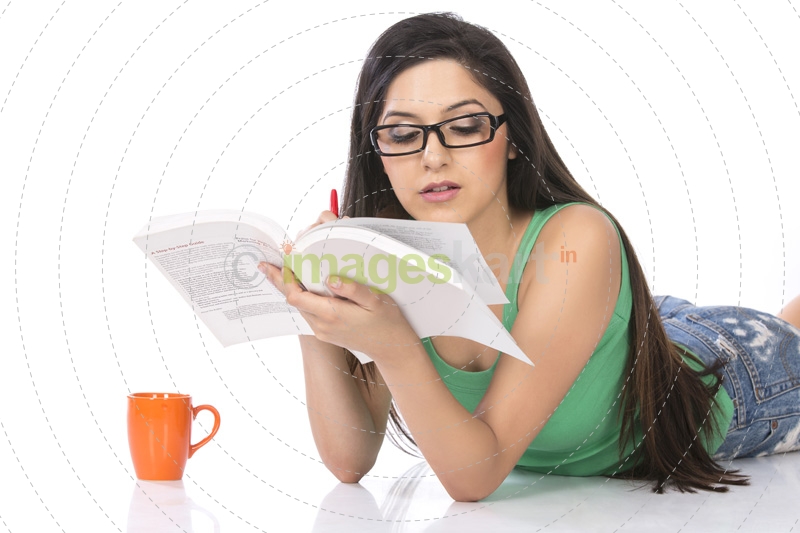 front view of a young teenage girl holding a pencil and a book