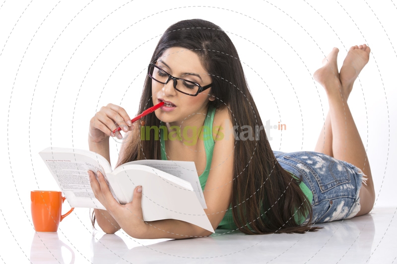 front view of a young teenage girl holding a pencil and a book