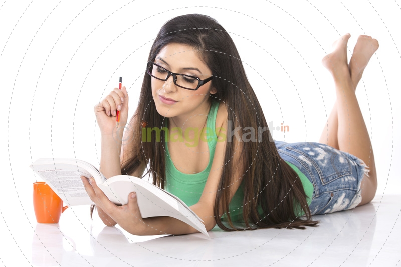 front view of a young teenage girl holding a pencil and a book