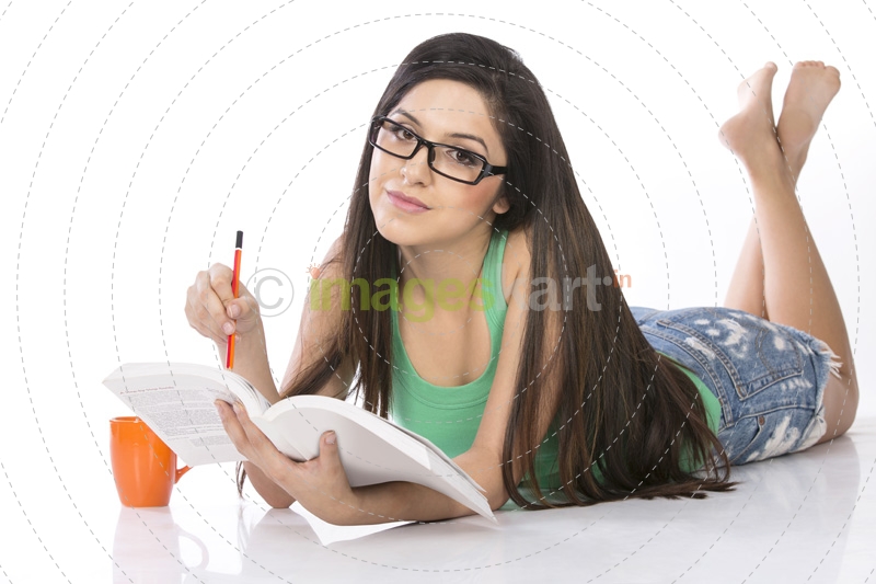 front view of a young teenage girl holding a pencil and a book