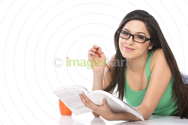 front view of a young teenage girl holding a pencil and a book
