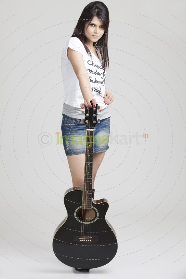 girl wearing short denims posing with a guitar