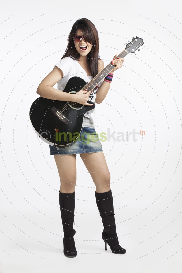 beautiful teenager playing guitar on white background