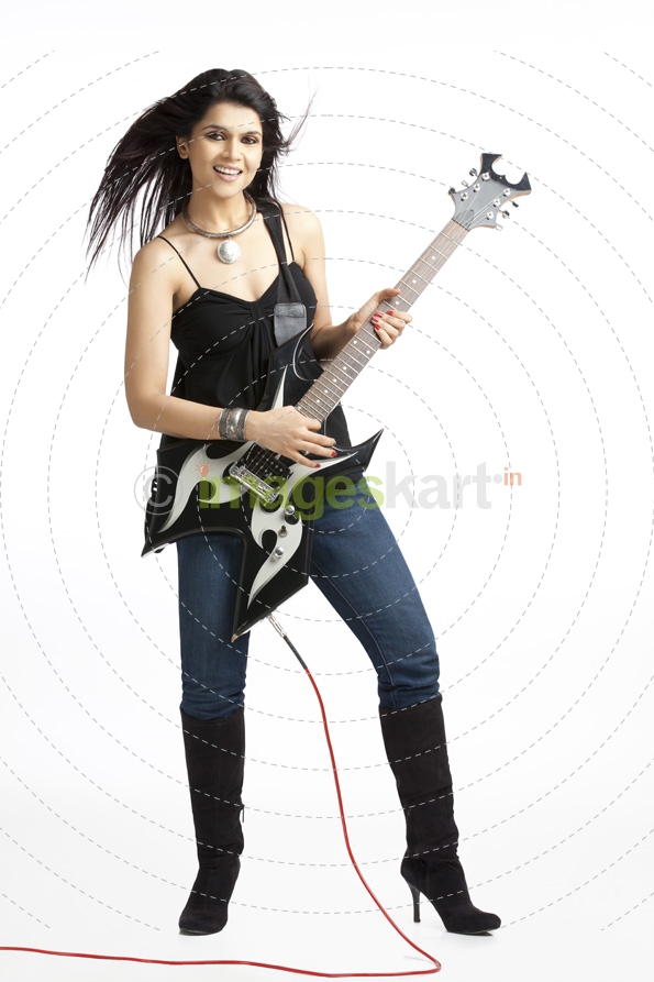 full length portrait of female rockstar holding a funky guitar