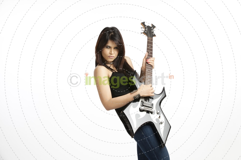 fashionable girl with an electric guitar playing hard-rock