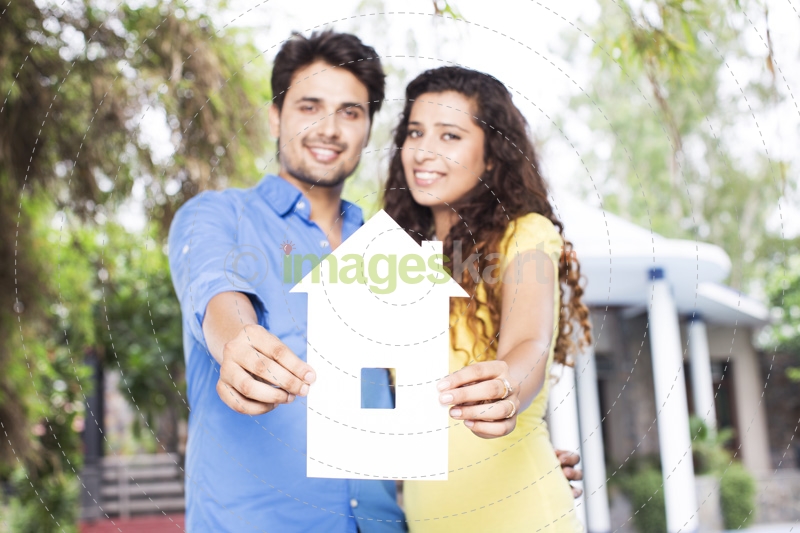 couple showing home shape paper cutout