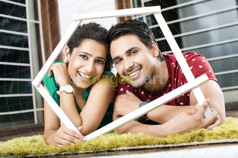 couple lying on rugs holding frame