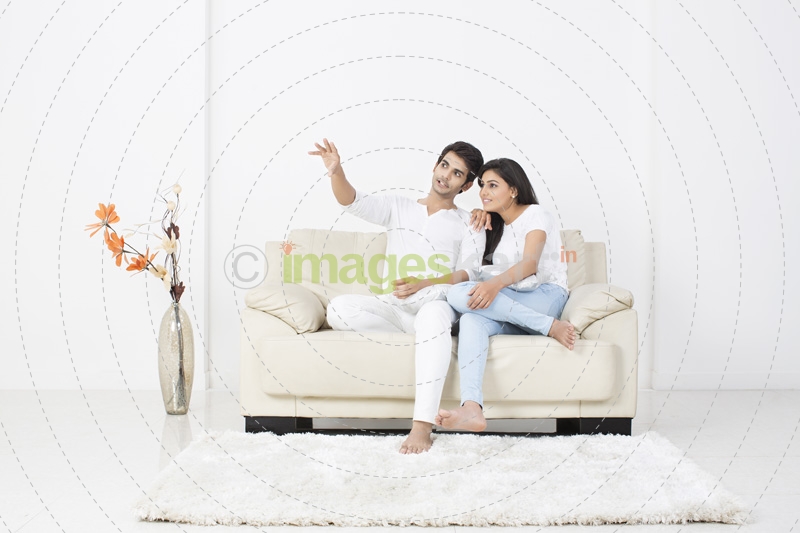couple conversing while sitting on couch