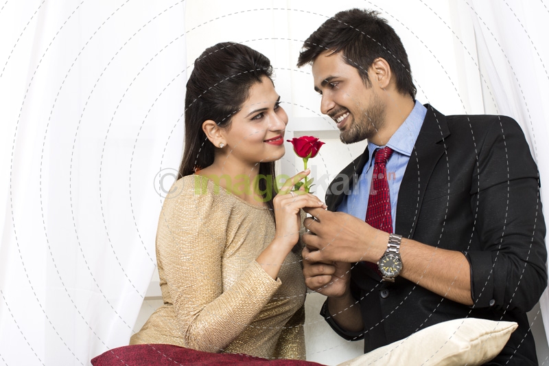 couple with rose looking at each other
