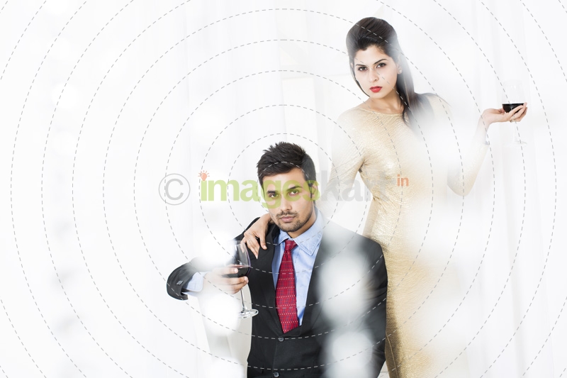 stylish couple posing with red wine
