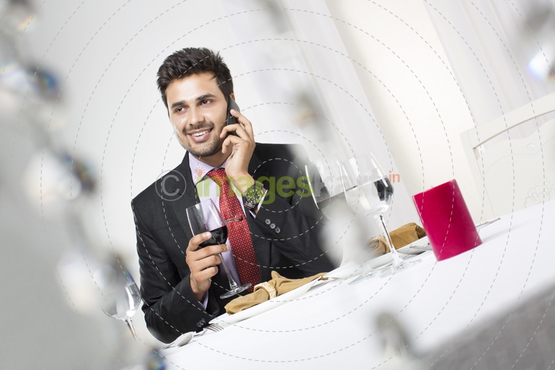 businessman on phone with a glass of wine