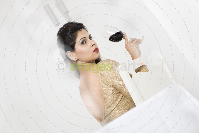 glamorous girl posing with wine glass against white background