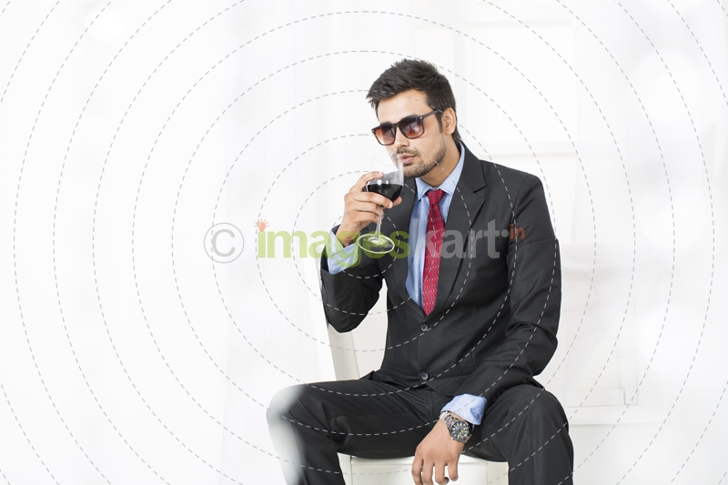 man in formals drinking wine 